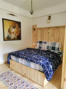 une chambre avec un lit avec une couette bleue et blanche dans l'établissement Nerve Cottage Homestay Bhowali, à Bhowāli