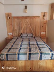 - un lit avec une tête de lit en bois dans l'établissement Nerve Cottage Homestay Bhowali, à Bhowāli 17 autres photos