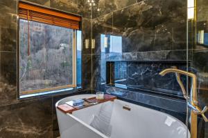a bathroom with a tub and a window at Reflections cabin in Sevierville +52 photos