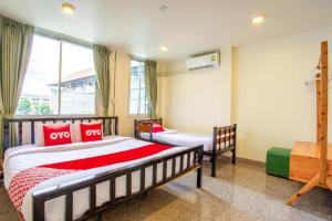 a bedroom with two beds and a window at OYO 928 Leaf Hostel in Chiang Mai