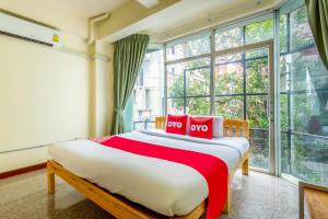 a bedroom with a large bed with red pillows at OYO 928 Leaf Hostel in Chiang Mai