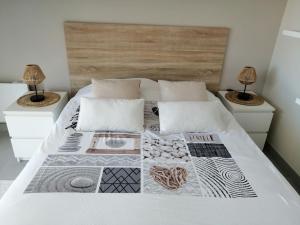 a bedroom with a white bed with two night stands at Cap sur l'océan in Saint-Brevin-les-Pins