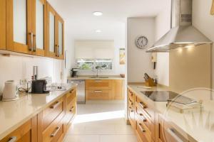 eine große Küche mit Holzschränken und einem Waschbecken in der Unterkunft Las Brisas 87 in Atamaría