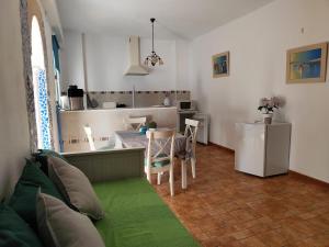 a living room with a couch and a kitchen at Studio Tropical in Cúllar-Vega