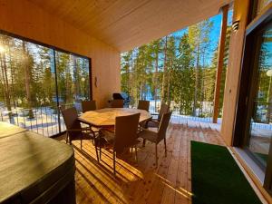 a dining room with a table and chairs in a house at Havu Resort Laajavuori - Luksushuvila keskellä suomalaista metsää, Jyväskylä in Jyväskylä