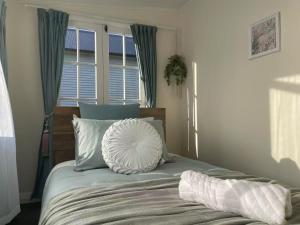 a bed with a pillow on it in a bedroom at Classic 4 bedrooms house opposite Waikato Hospital in Hamilton
