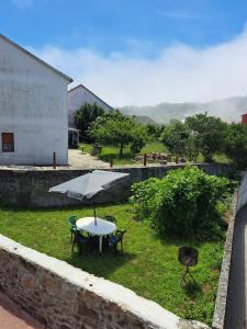 a table with an umbrella in the grass at A Casa de Isaura in Camariñas