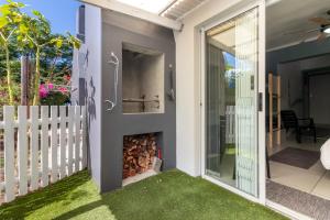 a garden with a fire place on the side of a house at Hartenbos Breakaway - LightHouse Cottage in Mossel Bay