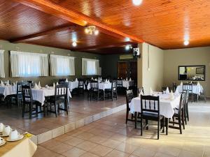 a dining room with white tables and chairs at Mbazwana Inn in Mbazwana