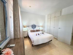 a bedroom with a white bed with shoes on it at PUSHE Village Albolote Business & Culture in Albolote