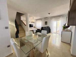 a living room with a glass table and white chairs at PUSHE Village Albolote Business & Culture in Albolote
