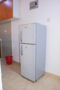 a white refrigerator in a kitchen with at Bamburi Luxury Homes II One bedroom apartment in Bamburi +7 photos