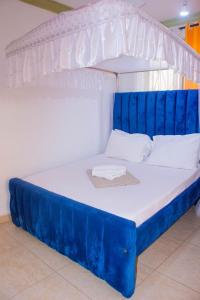 a blue and white bed in a room at Bamburi Luxury Homes II One bedroom apartment in Bamburi