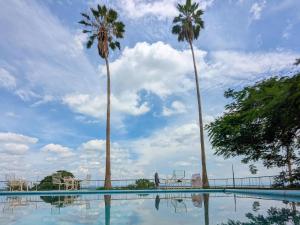 KaribaにあるCutty Sark Lodgeの2本のヤシの木とヤシの木のあるプール