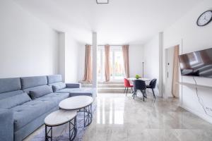 Una sala de estar con un sofá azul y una mesa. en Pine Living, en Múnich