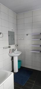 a bathroom with a sink and a mirror and a tub at Private cosy home close to city center with views in Kigali