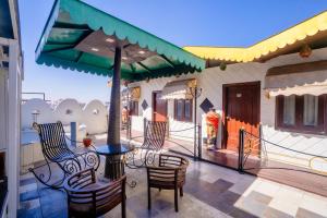 a patio with chairs and a table and an umbrella at Mahadev Regency Hotel in Jaipur