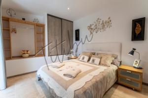 een slaapkamer met een groot bed met kussens erop bij Le Titibu, Gîte et Spa entre Ardèche et Provence, Clim, BBQ, Netflix, classé 5 étoiles in Saint-Paulet-de-Caisson +45 foto's