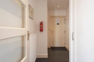 a hallway with a fire extinguisher on the wall at Garden House Harry in Zandvoort +52 photos