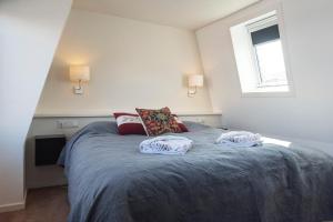 a bedroom with a bed with two pillows on it at Garden House Harry in Zandvoort