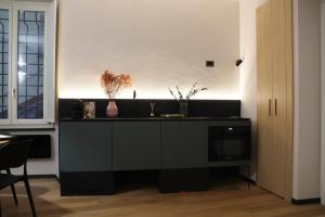 una cucina con bancone nero e vasi sopra di Luxury Design-Cattedrale di San Lorenzo a Genova Altre 6 foto