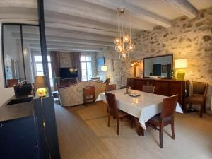 a living room with a table and a bedroom at Pierres anciennes et soirées douces Coeur de ville in Pézenas