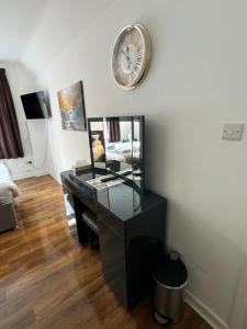 a room with a desk and a clock on the wall at Oakhurst Gatwick and holiday parking five pounds per day and transport between six am and eleven pm in Crawley