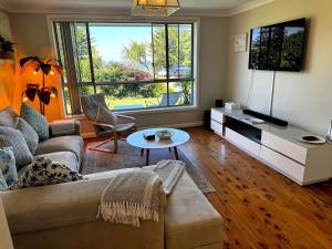 a living room with a couch and a table at Frogs by the Sea in Cronulla