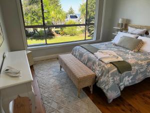 a bedroom with a bed and a large window at Frogs by the Sea in Cronulla