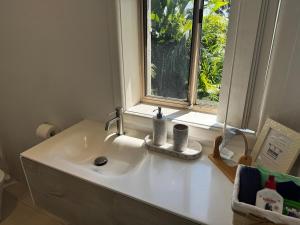 a white sink in a bathroom with a window at Frogs by the Sea in Cronulla +41 photos