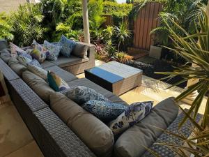 a couch with pillows sitting on a patio at Frogs by the Sea in Cronulla