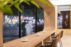 a row of tables in a restaurant with a couple in the street at NOX Hotel in Chengdu