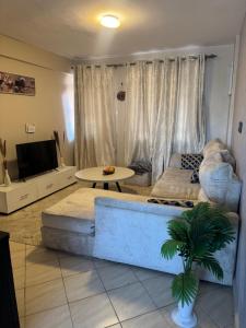 a living room with a couch and a table at Epic brownstone Apartments Phase 1 in Nairobi