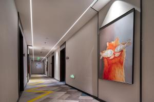 a hallway with a painting of a cat on the wall at NOX Hotel in Chengdu