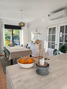a kitchen and dining room with a bowl of oranges on a table at B&B Villa Pinos Málaga in Alhaurín de la Torre