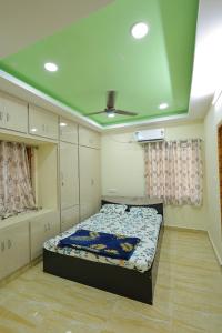 a bedroom with a bed and a ceiling at Bhakti Bliss Homestay - 2BHK modern Apartment with AC, Wifi and Android TV in Tirupati