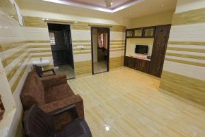 a living room with a couch and a television at Bhakti Bliss Homestay - 2BHK modern Apartment with AC, Wifi and Android TV in Tirupati