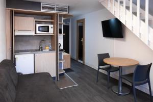 a room with a kitchen and a table and chairs at Suite Home Briancon Serre Chevalier in Briançon