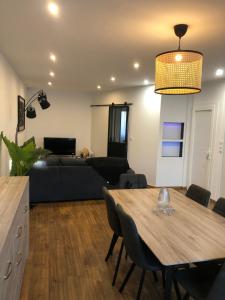 a living room with a table and a bed at APPARTEMENT F3 BOX Vélo Moto Centre historique in Mirepoix +9 photos
