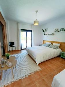 a bedroom with a large white bed and a table at B&B Villa Pinos Málaga in Alhaurín de la Torre +42 photos