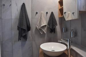 baño con lavabo blanco y toallas en la pared en Cycladic home in Kampos by GHH, en Kampos 21 fotos más