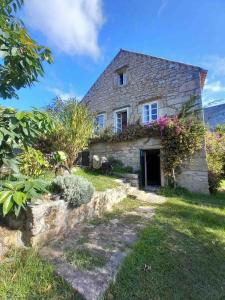 una vecchia casa di pietra con dei fiori sopra di Casa da Horta a Ribeira