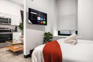 Un dormitorio con una cama con un televisor en la pared. en CozySuites Stunning 1BR in Downtown Pitts #6, en Pittsburgh