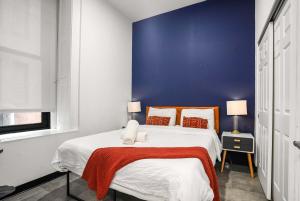 Un dormitorio con una cama grande con una pared azul. en CozySuites Stunning 1BR in Downtown Pitts #6, en Pittsburgh