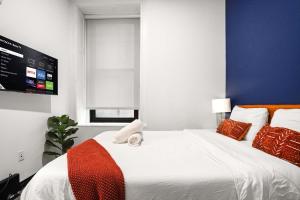 Un dormitorio con una cama grande con un televisor en la pared. en CozySuites Stunning 1BR in Downtown Pitts #6, en Pittsburgh