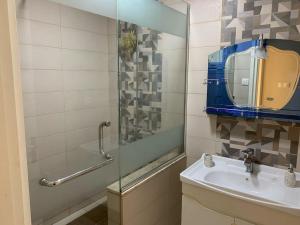 Ouled FayetBelle maison de 3 chambres avec jardin的带水槽和玻璃淋浴间的浴室
