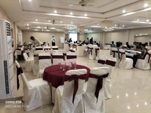 a banquet hall with white chairs and tables and people at Hotel Day IN One in Lahore