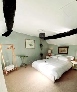 a bedroom with a large white bed in a room at Cosy and unique Thatched Cottage on Dartmoor in Bridford