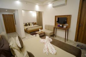 ein Zimmer mit einem Wohnzimmer mit einer Couch und einem Wohnzimmer in der Unterkunft Serenity By The Ganges in Haridwar