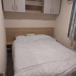 ein kleines Schlafzimmer mit einem weißen Bett darin in der Unterkunft Lovely 6 Berth Caravan With Wi-Fi At Dovercourt Holiday Park In Essex Ref 44201G in Great Oakley
